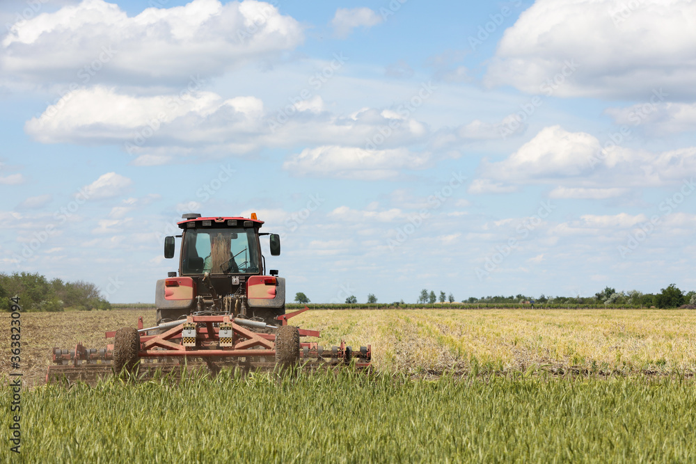 Modern agricultural machinery in field on sunny day Modern agricultural machinery in field on sunny day