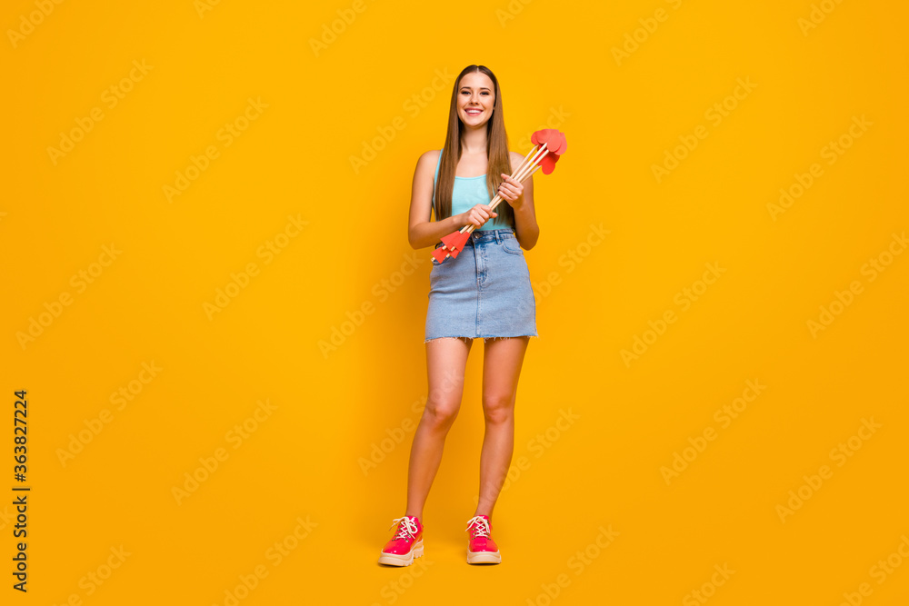Photo portrait of pretty cheerful glad nice attractive gorgeous teenager holding stack of arrows in hands isolated over vivid color yellow background Photo portrait of pretty cheerful glad nice attractive gorgeous teenager holding stack of arrows in hands isolated over vivid color yellow background