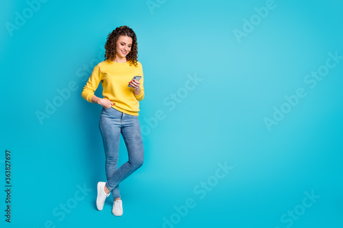 Full length body size view of her she nice attractive focused cheerful wavy-haired girl walking using device browsing media multimedia isolated over bright vivid shine vibrant blue color background