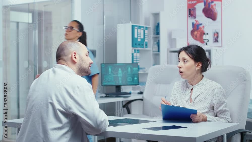 Woman filling out forms, asking doctor about something she does not know. Healthcare in modern hospital or private clinic, disease prevention and consultation in medic office treatment medication Woman filling out forms, asking doctor about something she does not know. Healthcare in modern hospital or private clinic, disease prevention and consultation in medic office treatment medication