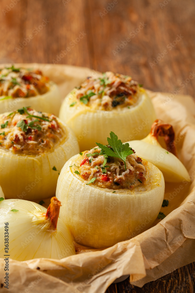 Onion baked with cheese stuffed with minced meat. Front view. Served in parchment. Onion baked with cheese stuffed with minced meat. Front view. Served in parchment.