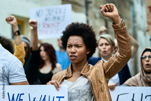 Photos African American woman with raised fist participating in a protest for human rights