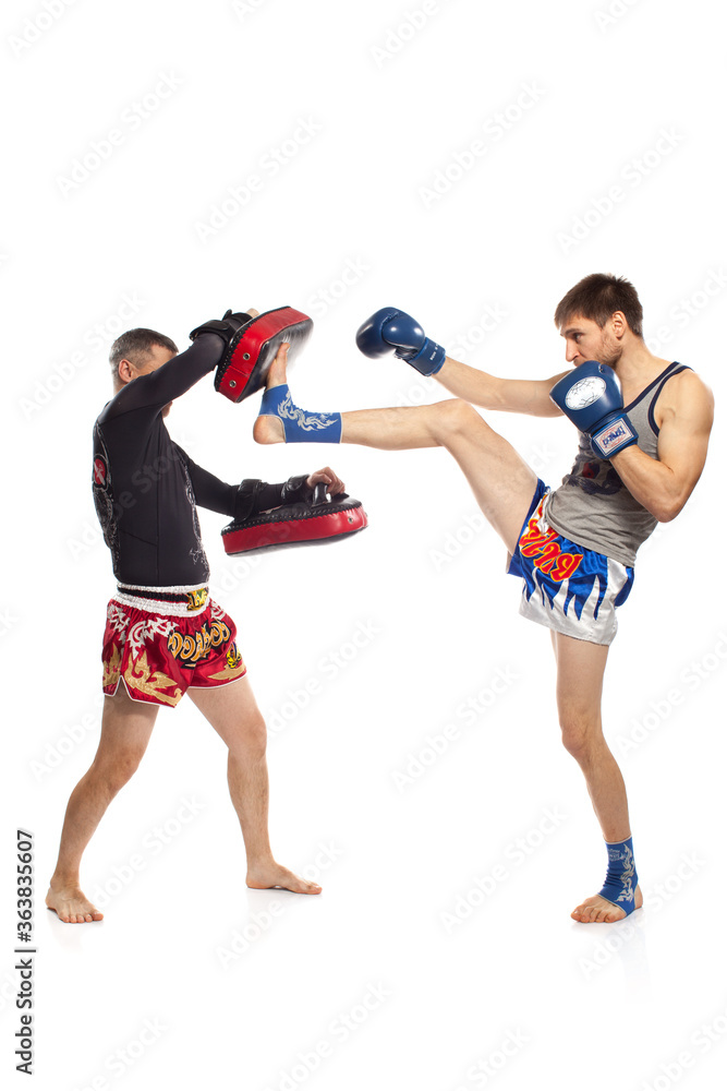 Two caucasian men exercising thai boxing in  studio on white background