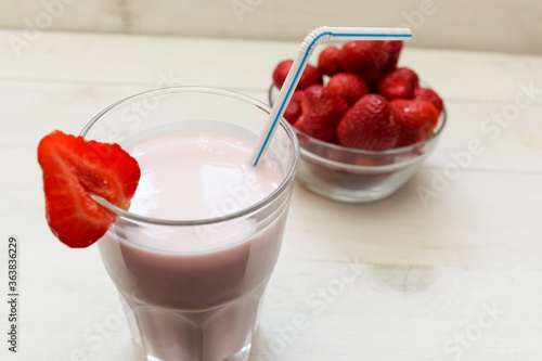 Strawberry Smoothie or Cocktail in a Glass with Straw and Garnish on a white Background