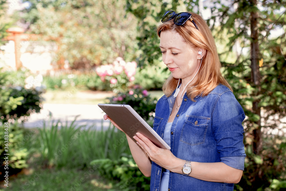 freelancer girl from the device: laptop, tablet, player, notebook, lying on the grass and working freelancer girl from the device: laptop, tablet, player, notebook, lying on the grass and working