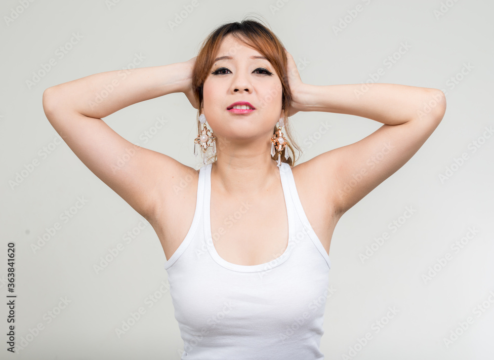 Portrait of happy beautiful Asian woman with hands behind head ready for gym Portrait of happy beautiful Asian woman with hands behind head ready for gym