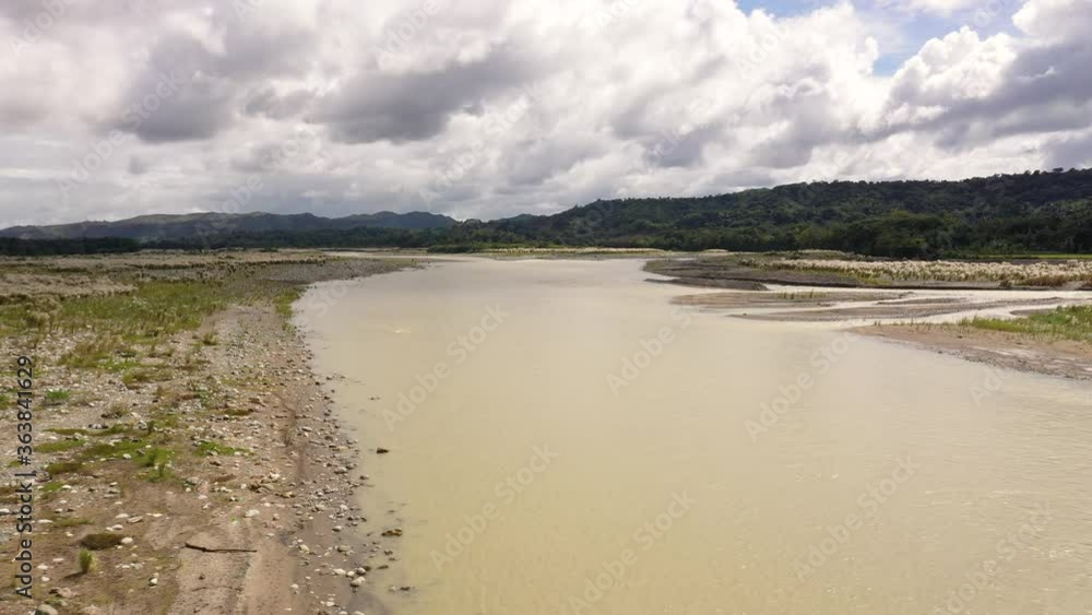 Mountain river and sky with cumulus clouds, top view. Top view on the valley of a mountain river. The nature of Luzon Island, Philippines. Mountain river and sky with cumulus clouds, top view. Top view on the valley of a mountain river. The nature of Luzon Island, Philippines.
