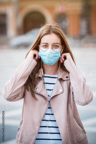 Young woman wearing medical face mask to protect herself from pollution, germs and coronavirus