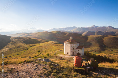 People looking sunset. Mountain ancient ruins at sunset. Medieval ruins of Rocca Calascio church landscape in background. Relax in mountain with hills and forest at dusk, hiking and trekking tourism photo