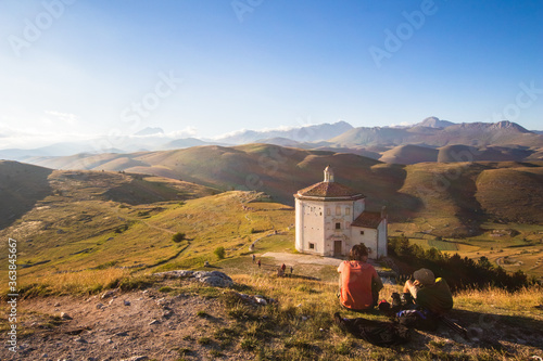People looking sunset. Mountain ancient ruins at sunset. Medieval ruins of Rocca Calascio church landscape in background. Relax in mountain with hills and forest at dusk, hiking and trekking tourism