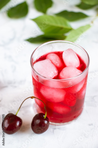 Wallpaper Mural Cherry fruit drink in a glass cup, cherry berries and green leaves on a white background. A refreshing summer drink. Top view. Torontodigital.ca