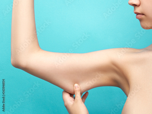 Modern Art activity about anorexia as an eating disorder characterized by an abnormally low body weight. Cropped shot of an emaciated lady stretching skin on her thin arm. 