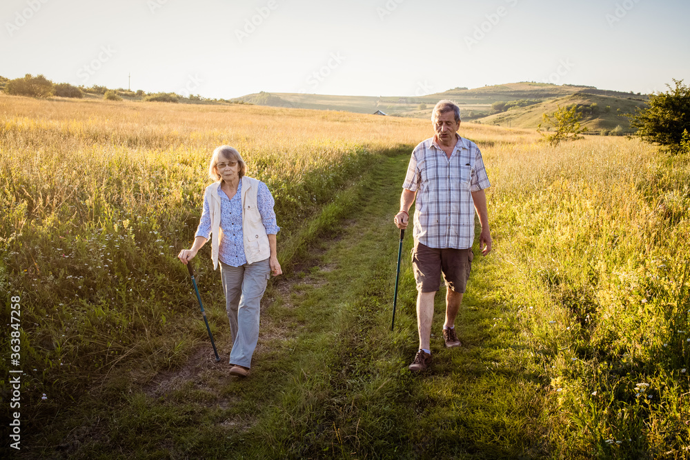 elderly couple trekking in a rural area social distancing