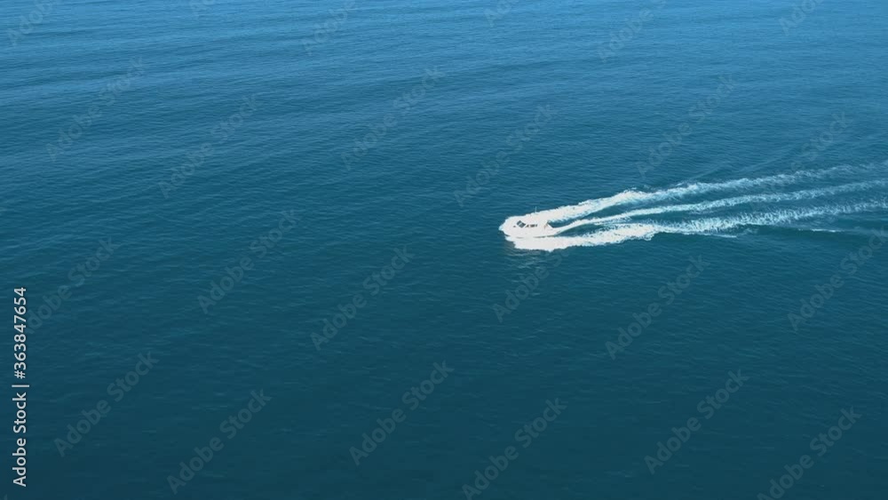 Aerial view of luxury white speed boat cruising in the blue calm sea Aerial view of luxury white speed boat cruising in the blue calm sea