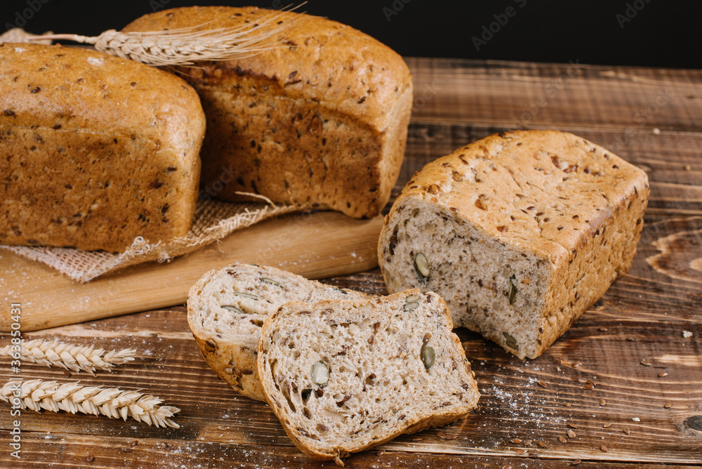 Fresh crunchy bread loafs and pieces on the wooden background