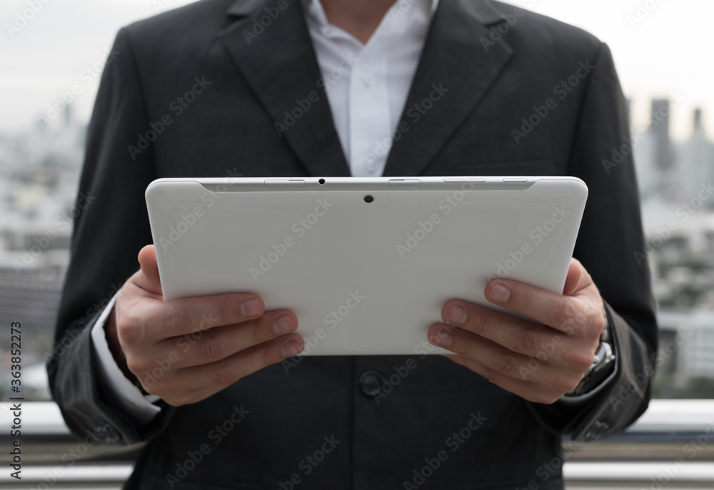 Businessman using digital tablet against view of the city Businessman using digital tablet against view of the city