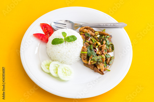  spicy chicken salad  and rice on table yellow