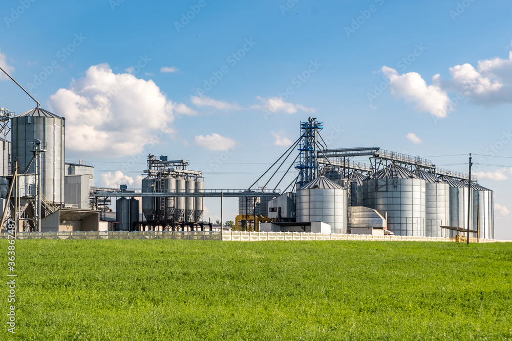silver silos on agro-processing and manufacturing plant for processing drying cleaning and storage of agricultural products, flour, cereals and grain. Granary elevator. silver silos on agro-processing and manufacturing plant for processing drying cleaning and storage of agricultural products, flour, cereals and grain. Granary elevator.