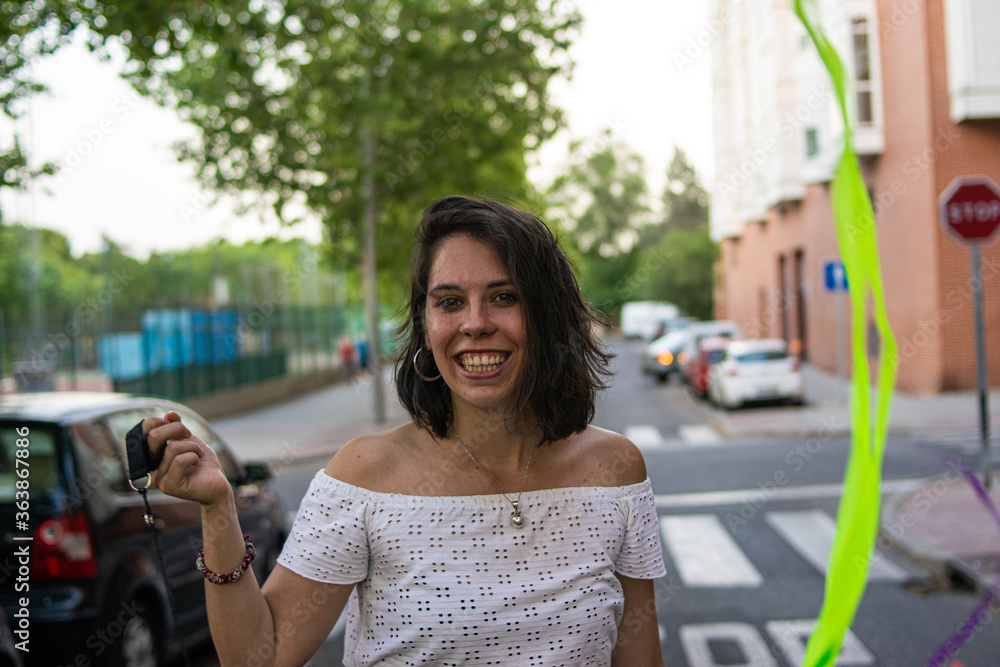 Fototapeta premium Photo of a young and attractive woman playing doing juggle with some colourful strips 