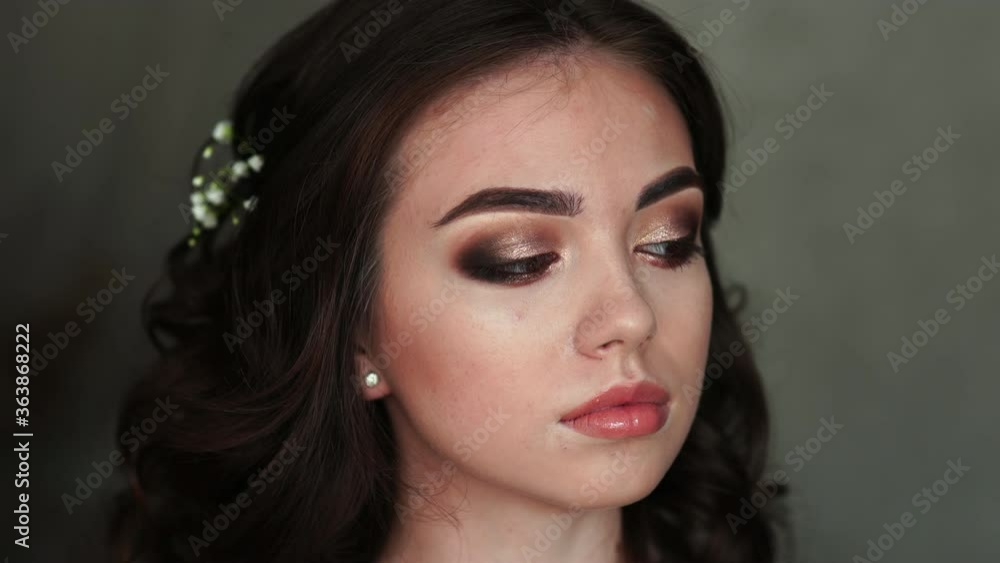 Girl makeup artist paints eyelashes on the model. Girl makeup artist paints eyelashes on the model.