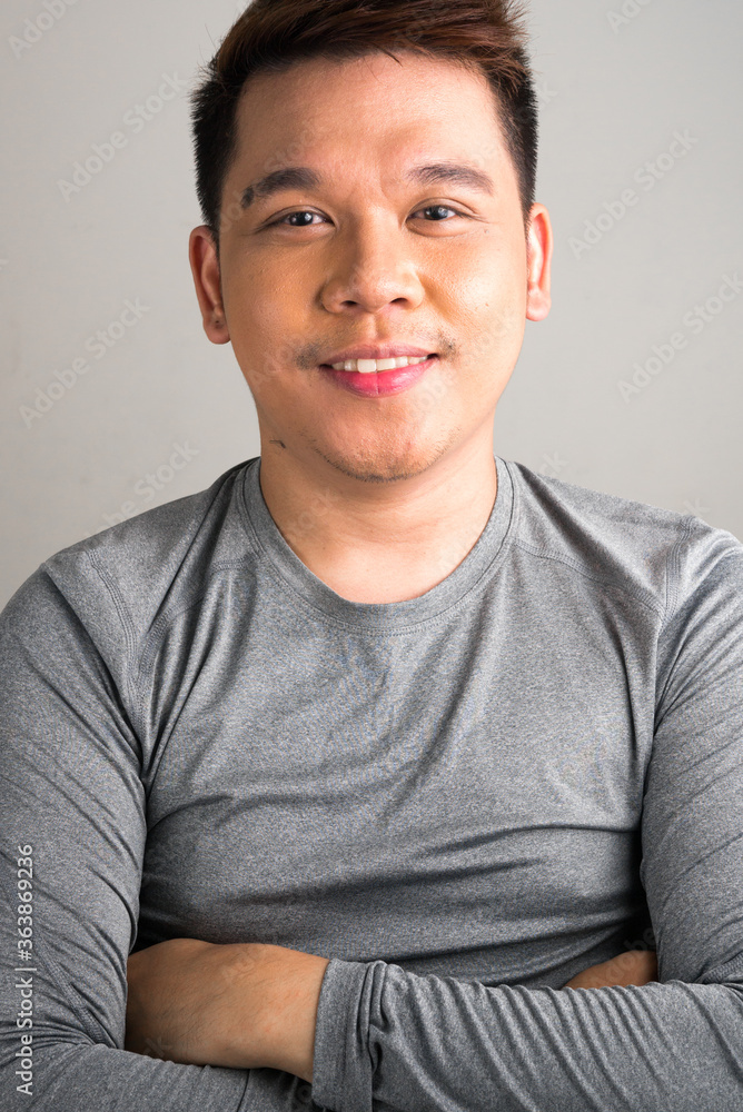 Portrait of happy young handsome Asian man smiling with arms crossed Portrait of happy young handsome Asian man smiling with arms crossed