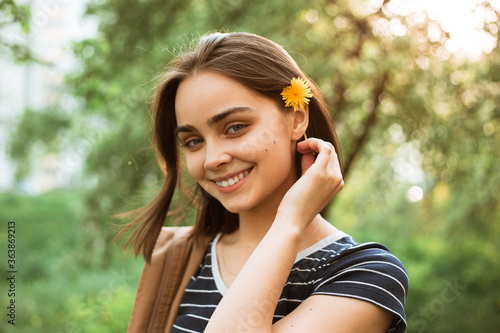 Wallpaper Mural Tender woman with dandelion flower in hair standing in green garden in summer while enjoying nature and looking at camera  Torontodigital.ca