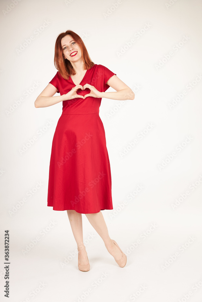 Smiling redhead girl on white background red dress Smiling redhead girl on white background red dress