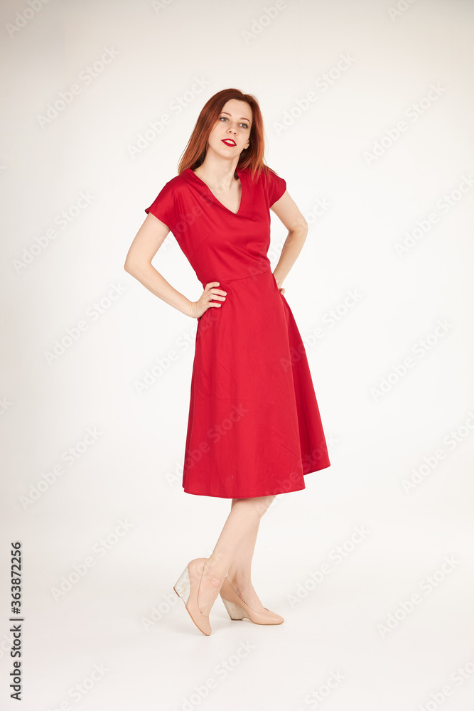 Smiling redhead girl on white background red dress Smiling redhead girl on white background red dress