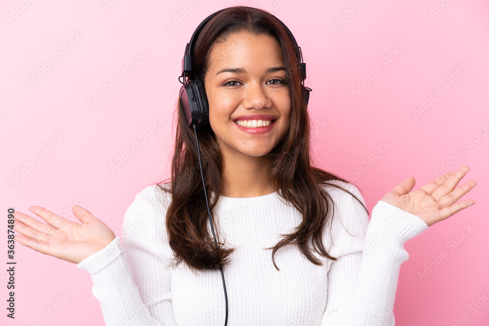 Young woman with earphones over isolated pink wall Young woman with earphones over isolated pink wall