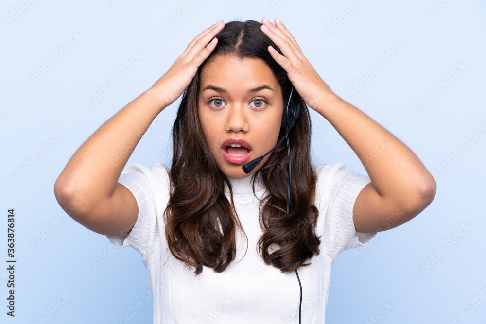 Young telemarketer Colombian woman over isolated blue background with surprise facial expression Young telemarketer Colombian woman over isolated blue background with surprise facial expression