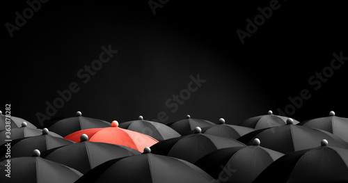 Slika na platnu Concept image with lots of black umbrellas and a red umbrella that stands out