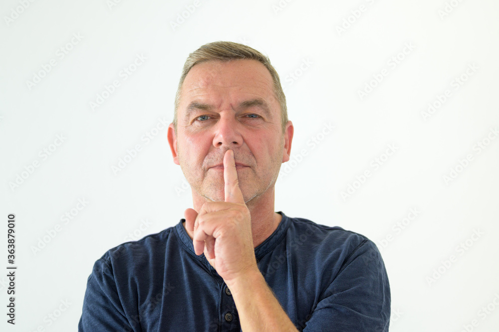 Thoughtful man standing with finger to lips Thoughtful man standing with finger to lips