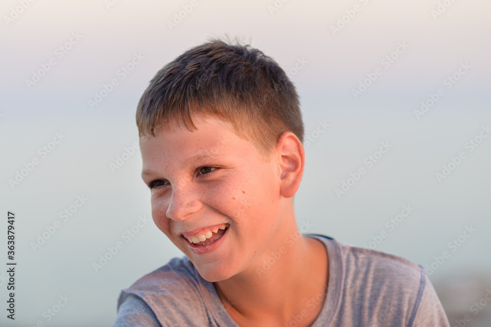 Portrait of a smiling boy, close-up, tan, evening shot. Portrait of a smiling boy, close-up, tan, evening shot.