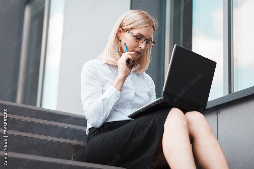 Busy business woman working on laptop outdoors Busy business woman working on laptop outdoors