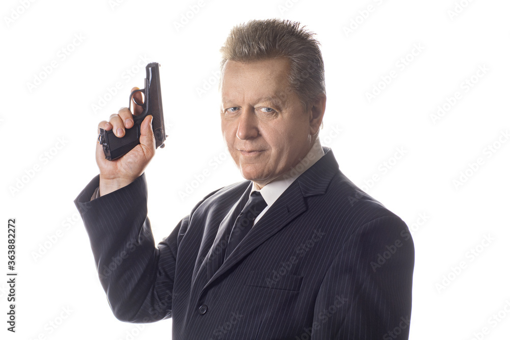 Side view portrait of a handsome man holding a gun. Strong middle-aged man is holding pistol in hand Side view portrait of a handsome man holding a gun. Strong middle-aged man is holding pistol in hand