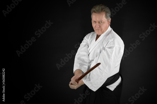 Portrait aikido master wearing traditional samurai hakama kimono. learning fight with bamboo boken