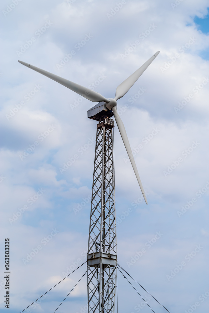 Wind turbine on a metal truss tower against a cloudy sky. The picture was taken in Russia, in the Orenburg region, in the countryside Wind turbine on a metal truss tower against a cloudy sky. The picture was taken in Russia, in the Orenburg region, in the countryside