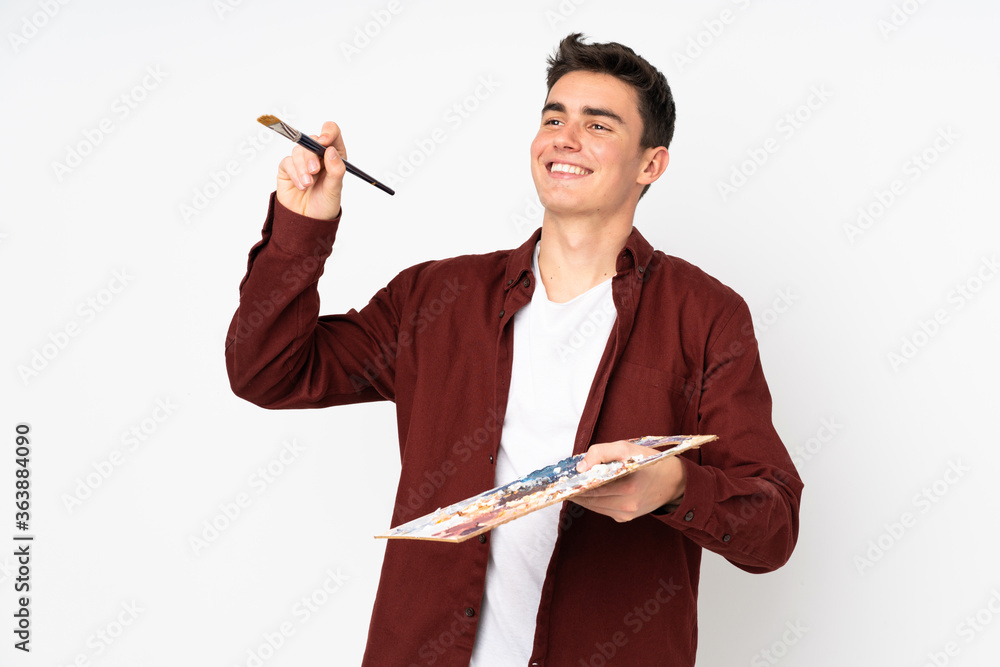 Teenager artist man holding a palette isolated on white background Teenager artist man holding a palette isolated on white background
