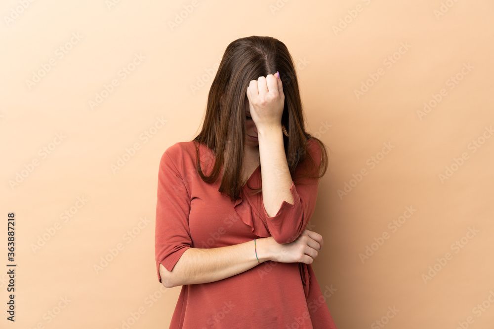 Young caucasian woman isolated on beige background with headache Young caucasian woman isolated on beige background with headache