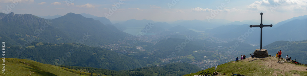 People at cross of Motto on Capriasca velley over Lugano in Switzerland People at cross of Motto on Capriasca velley over Lugano in Switzerland
