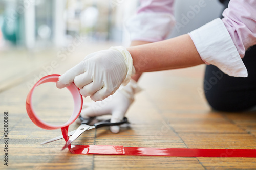 Business woman marks floor with red tape photo