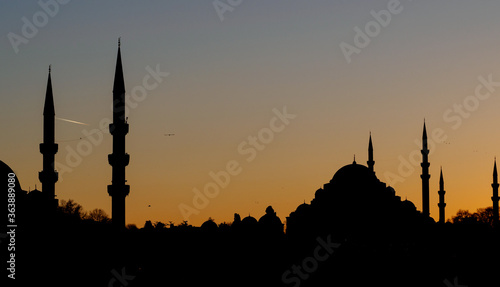 Black silhouette of the city with mosques at sunset