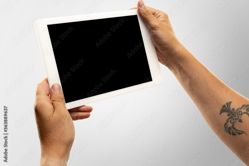 Close up male hands holding tablet with blank screen during online watching of popular sport matches, championships. Copyspace for advertising. Devices, gadgets, technologies concept. Close up male hands holding tablet with blank screen during online watching of popular sport matches, championships. Copyspace for advertising. Devices, gadgets, technologies concept.