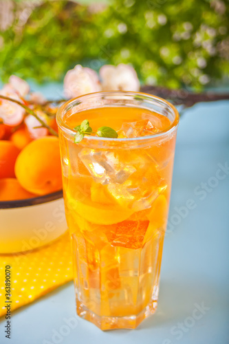 Summer cold drinks homemade apricot lemonade ice tea with ice cubes and mint