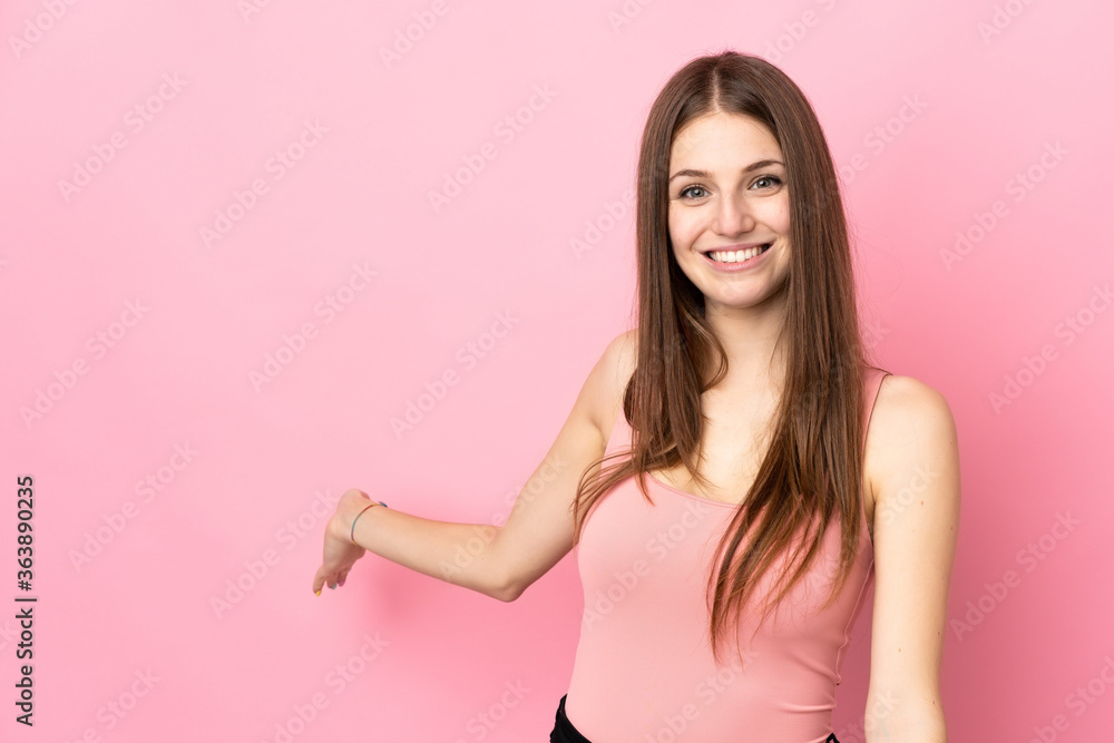 Young caucasian woman isolated on pink background extending hands to the side for inviting to come Young caucasian woman isolated on pink background extending hands to the side for inviting to come