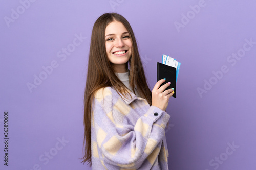 Young caucasian woman isolated on purple background happy in vacation with passport and plane tickets
