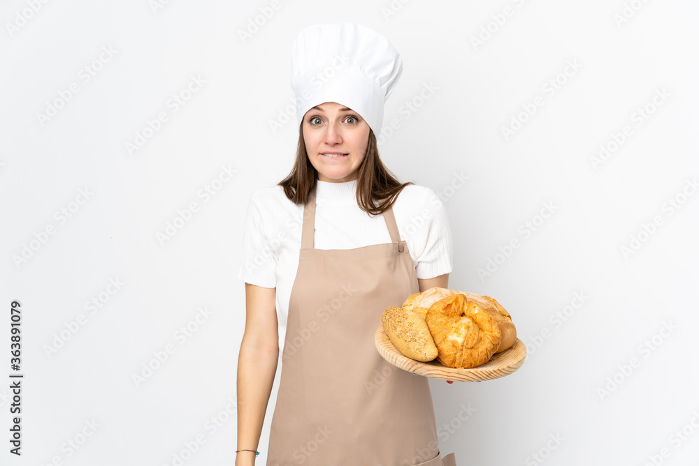 Young woman in chef uniform isolated on white background having doubts and with confuse face expression Young woman in chef uniform isolated on white background having doubts and with confuse face expression