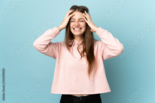 Young caucasian woman isolated on blue background laughing