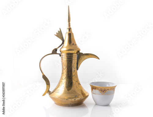 Traditional arabic coffee mug called Dallah and coffee cup on white background - stock image