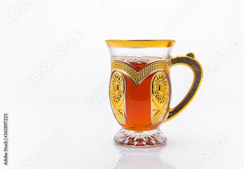 An ornamental cup of sulemani tea on white background. Arabic black tea called Suleimani. photo